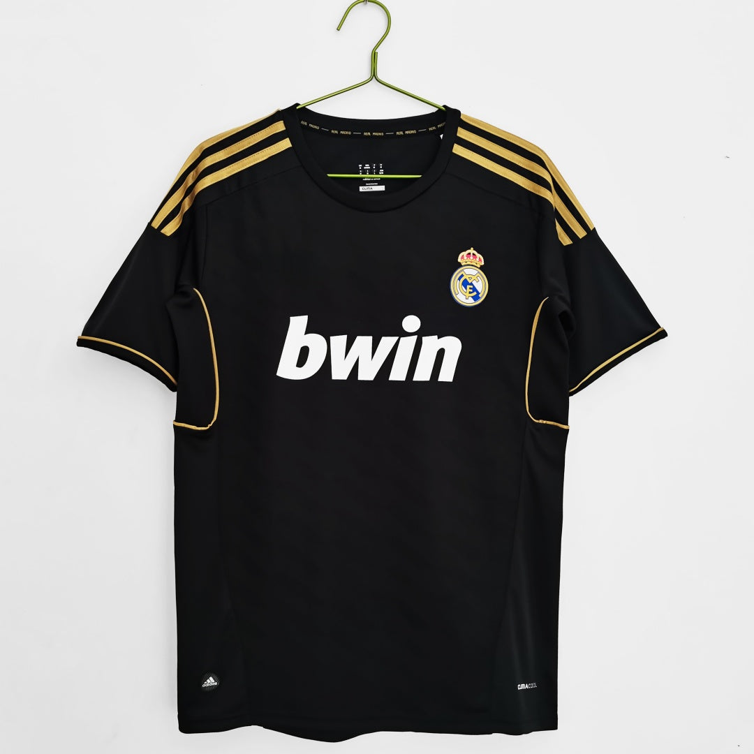 Maillot rétro Extérieur Real Madrid 2011-2012, marque Le 12-ème Maillot, avec logo et design classique blanc et violet.