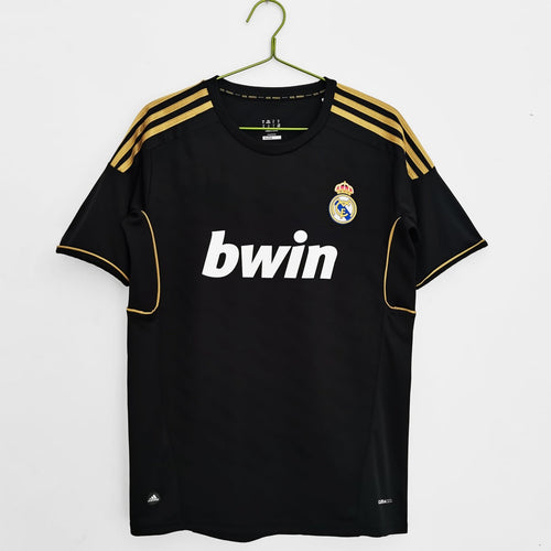 Maillot rétro Extérieur Real Madrid 2011-2012, marque Le 12-ème Maillot, avec logo et design classique blanc et violet.