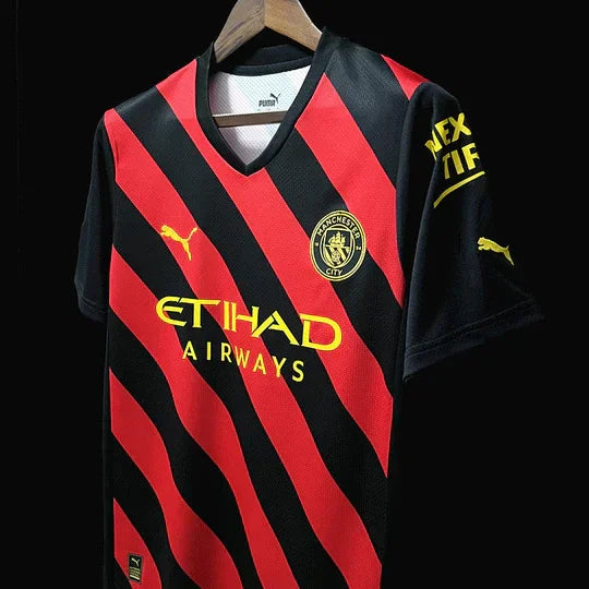 Maillot Manchester City 2022/23 Le 12 -ème Maillot, maillot de football bleu avec logo et détails blancs.
