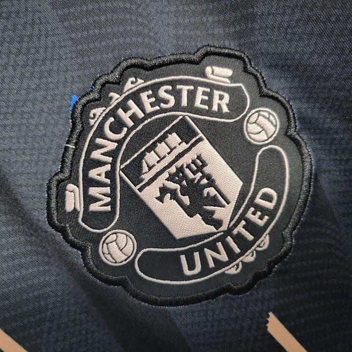 Maillot d'entraînement Manchester United 2023 Le 12-ème, maillot de sport rouge avec logo du club et détails de ventilation.