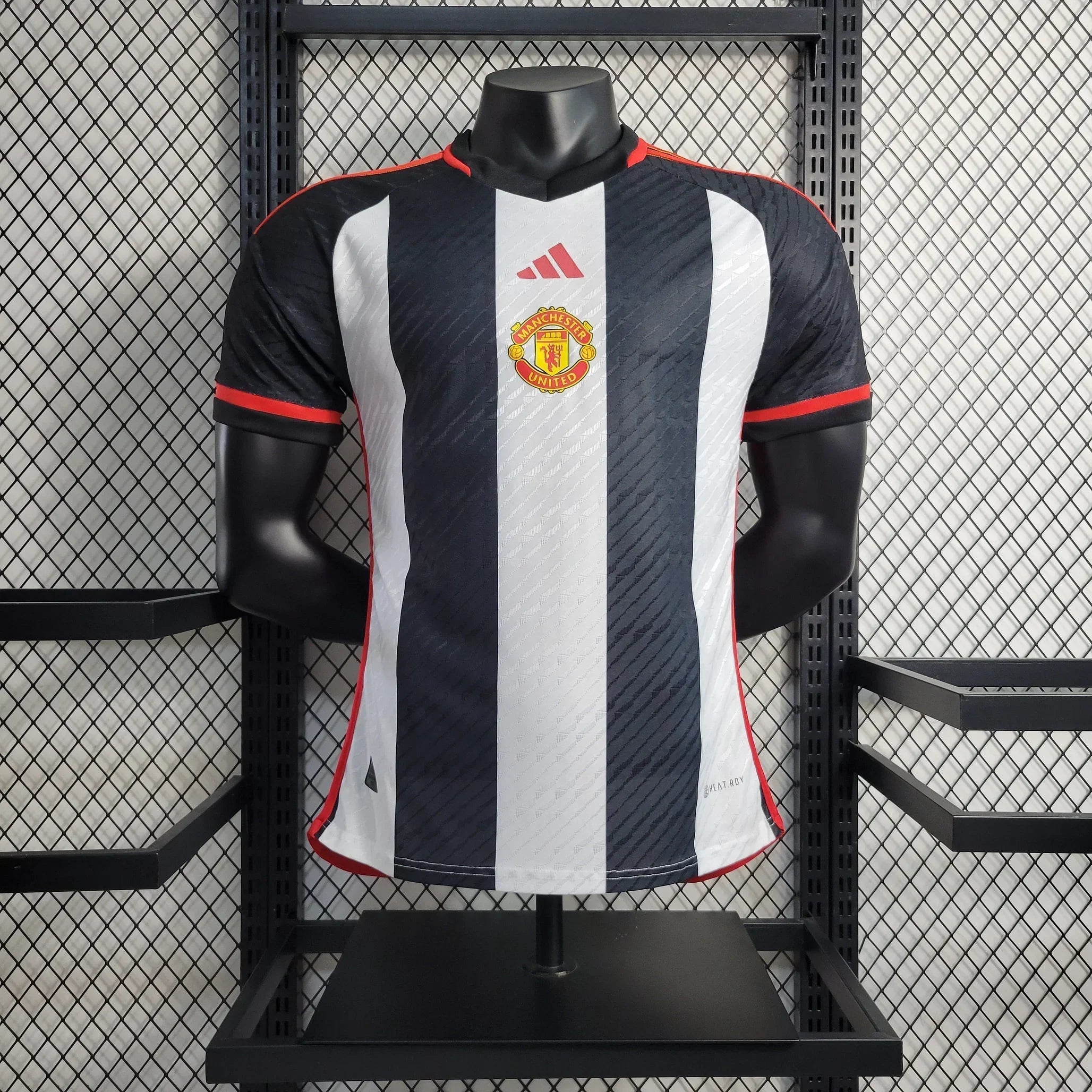 Maillot Manchester United 2023-2024 Le 12 -ème Maillot, maillot de football rouge avec logo du club et détails de l'équipe.