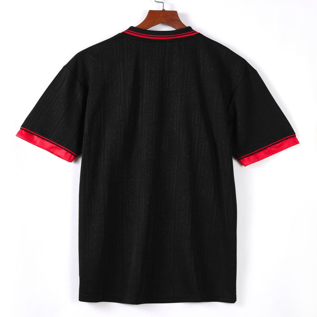 Maillot rétro third de l'AC Milan 1997-1998, marque Le 12ème, vue de face avec logo et détails du design orange et noir.