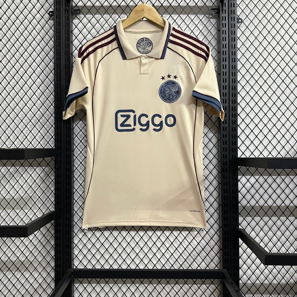 Maillot Ajax troisième 2025/26 de la marque Le 12, vue de face avec détails du design orange et bleu.