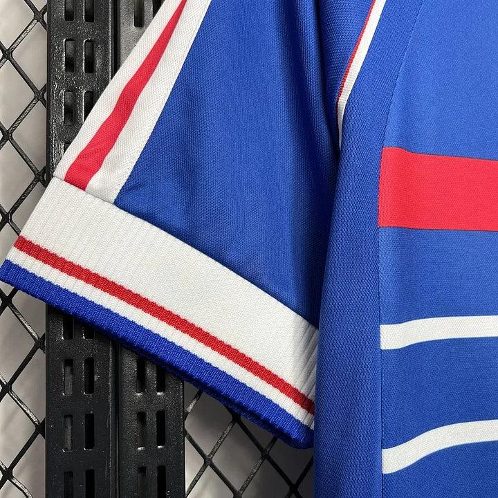 Maillot France rétro de la saison 1998, fabriqué par Le 12-ème Maillot, affichant les couleurs officielles de l'équipe nationale.