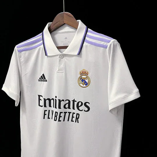 Maillot domicile Real Madrid 2022-2023, marque Le 12-ème Maillot, vue de face avec logo et détails du maillot blanc et bleu.