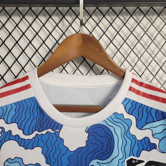 Maillot Japon Édition Spéciale 2022-23 Le 12, devant blanc avec motifs rouges et détails bleus, logo officiel du Japon.