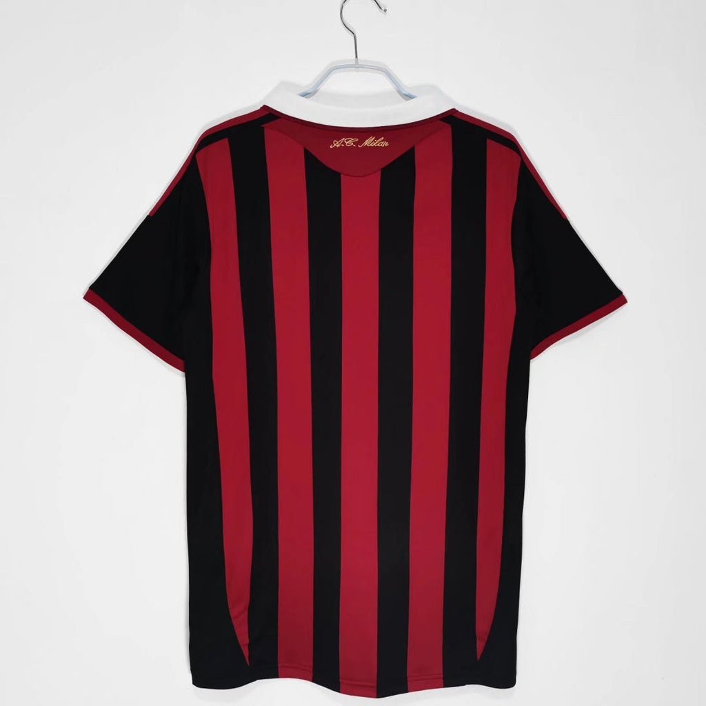 Maillot domicile rétro 2009-2010 AC Milan Le 12-ème Maillot, maillot de football rouge avec le logo du club et les détails du design.