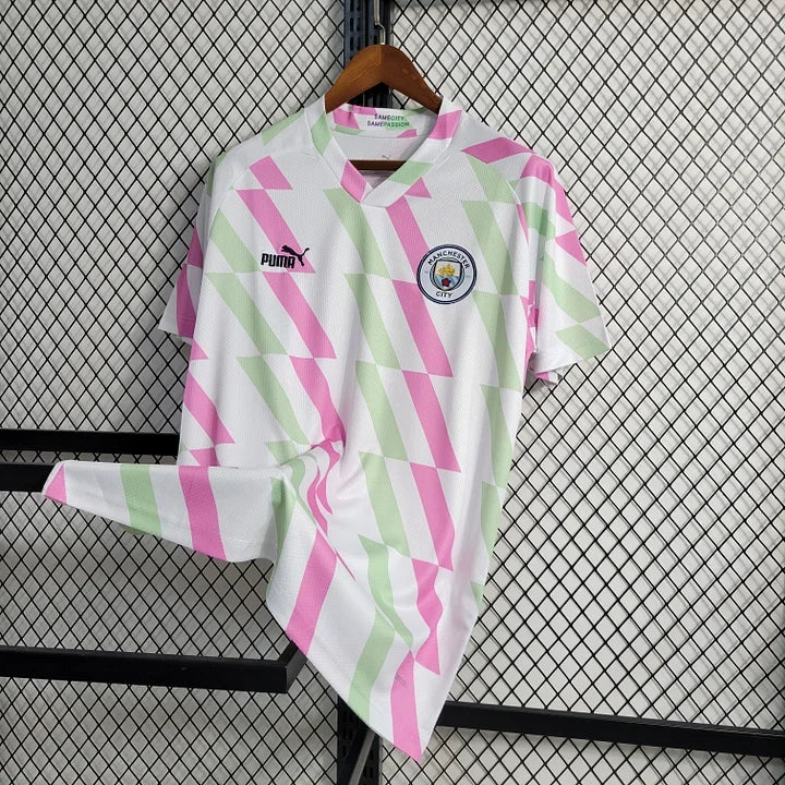 Maillot d'entraînement Manchester City 2023-2024, marque Le 12-ème Maillot, vue de face, tissu bleu avec logo du club.