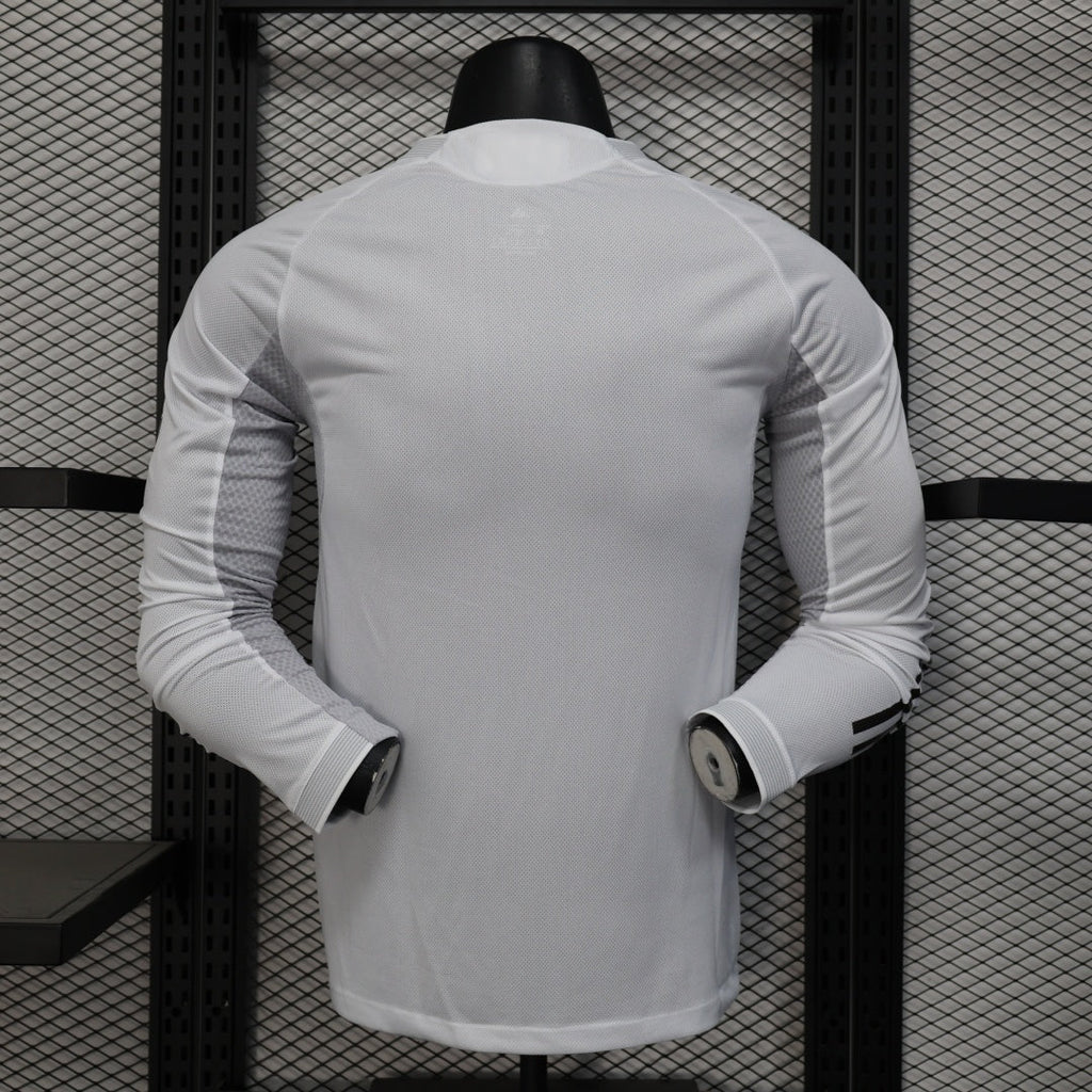 Maillot domicile Real Madrid 25/26, manches longues, par Le 12, maillot de football blanc avec logo du club et détails bleus.