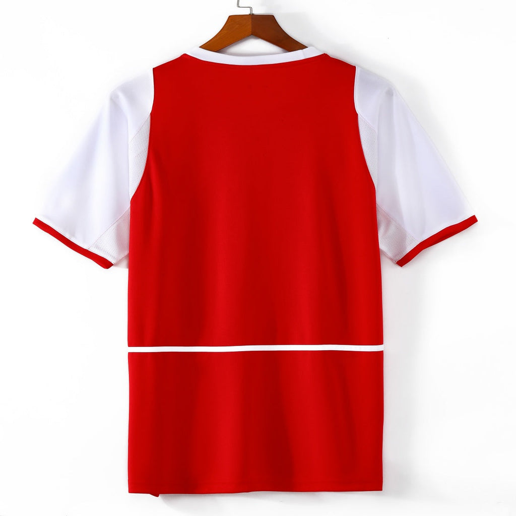 Maillot domicile retro de l'Arsenal 2002-2004, signé Le 12 -ème Maillot, en tissu rouge avec détails blancs.