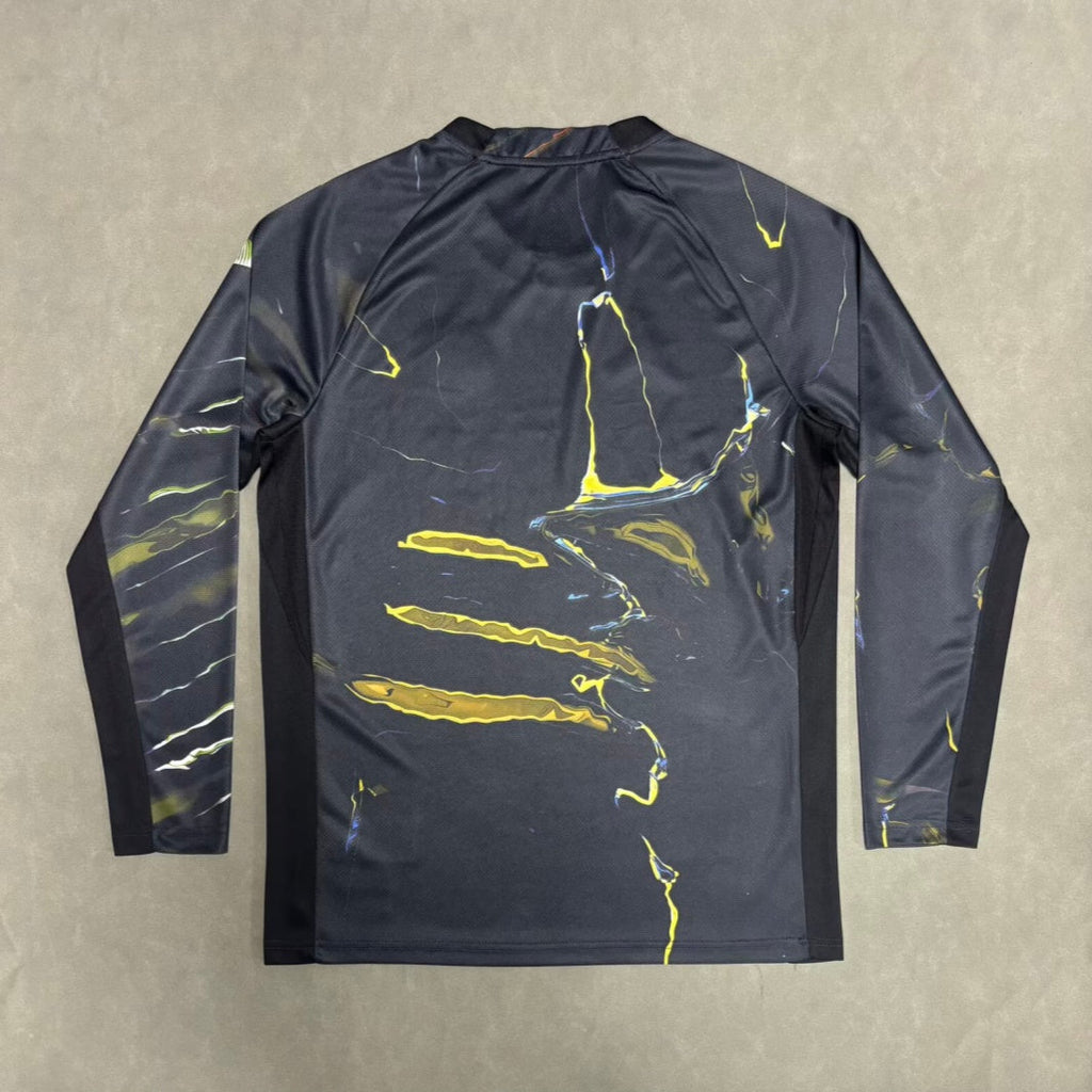 Maillot PSG Night Edition Stadium à manches longues, marque Le 12-ème Maillot, en tissu bleu avec logo du PSG visible.