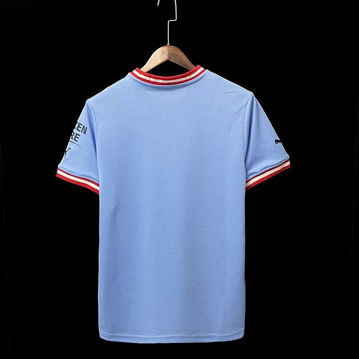 Maillot domicile Manchester City 2022/23 Le 12 -ème Maillot, maillot de football bleu avec logo et détails de l'équipe.