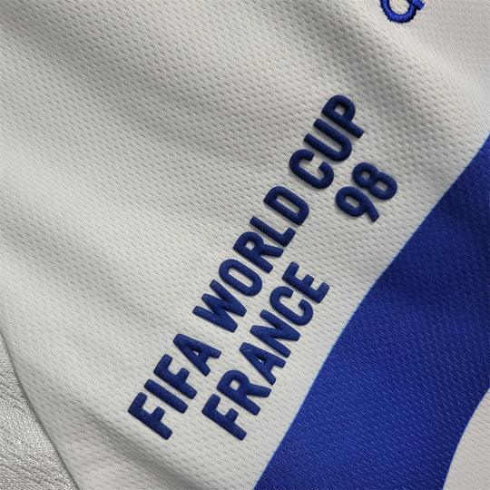 Maillot rétro de l'équipe de France 1998, marque Le 12 -ème Maillot, avec logo et design vintage visible sur l'image.