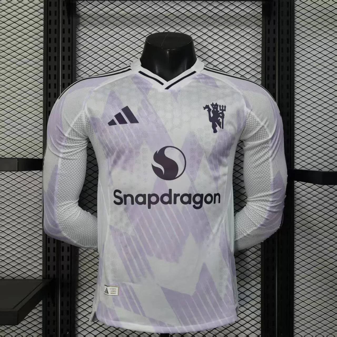 Maillot Manchester United manches longues 2025-26 Le 12-ème Maillot, maillot de football rouge avec logo et détails de l'équipe.