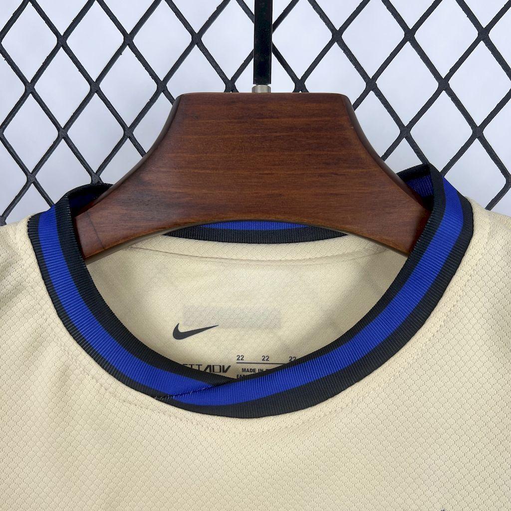 Jeune enfant portant le kit extérieur du FC Barcelone 2025-26 de Le 12 -ème Maillot, maillot bleu avec logo du club.