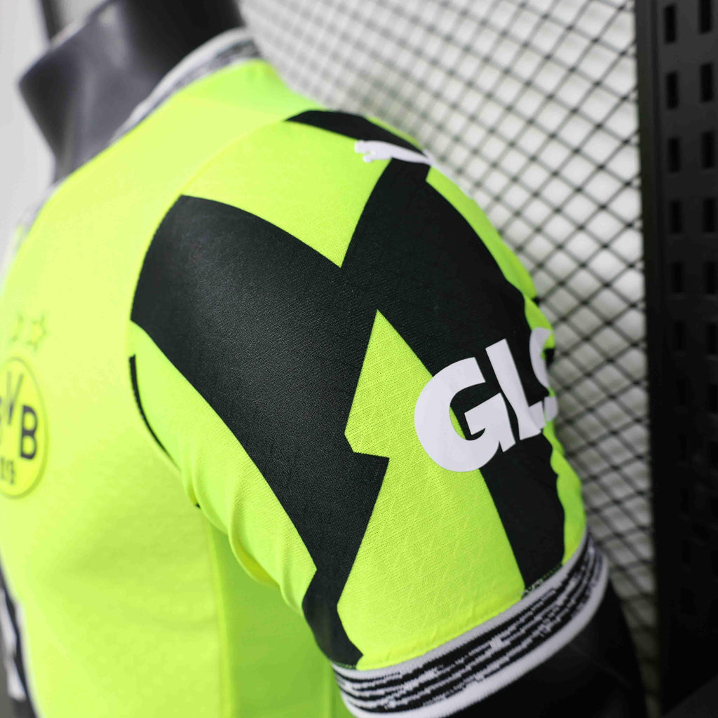 Maillot Dortmund concept 25-26 ans, de style moderne, porté par un mannequin, en bleu avec détails blancs, de la marque Le 12-ème Maillot.