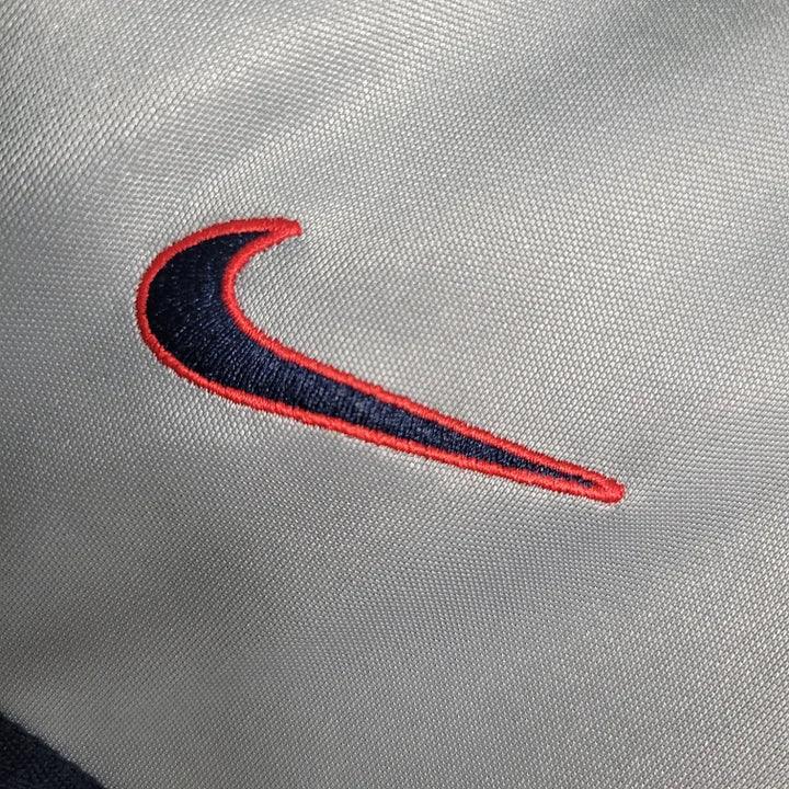 Maillot Paris Retro 2000 de Le 12 -ème Maillot, vue de face avec détails du logo et design vintage bleu et blanc.