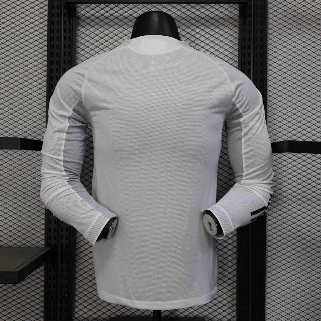 Maillot à manches longues Real Madrid 25-26, modèle Le 12-ème Maillot, blanc avec logo du club, porté par un supporter.