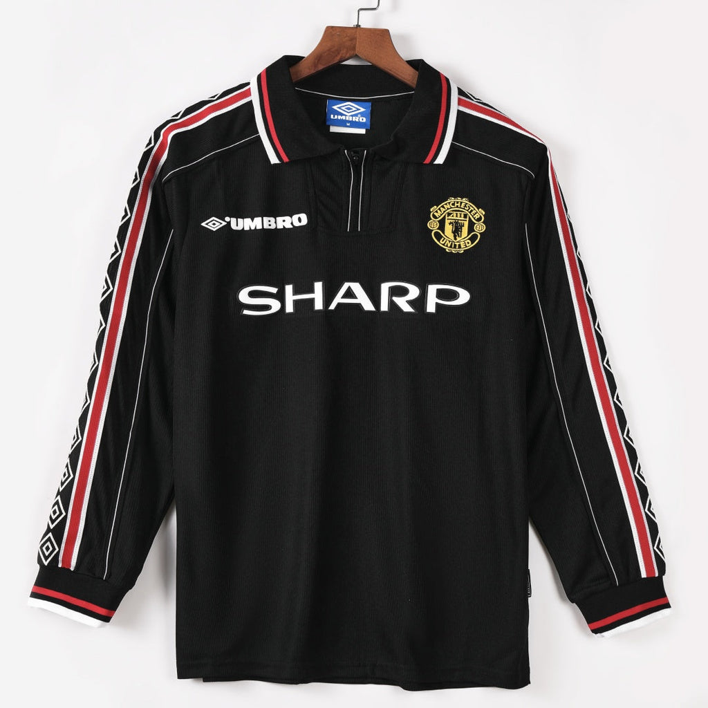 Maillot extérieur Manchester United rétro 1998-1999 à manches longues, marque Le 12 -ème Maillot, tissu rouge et blanc.