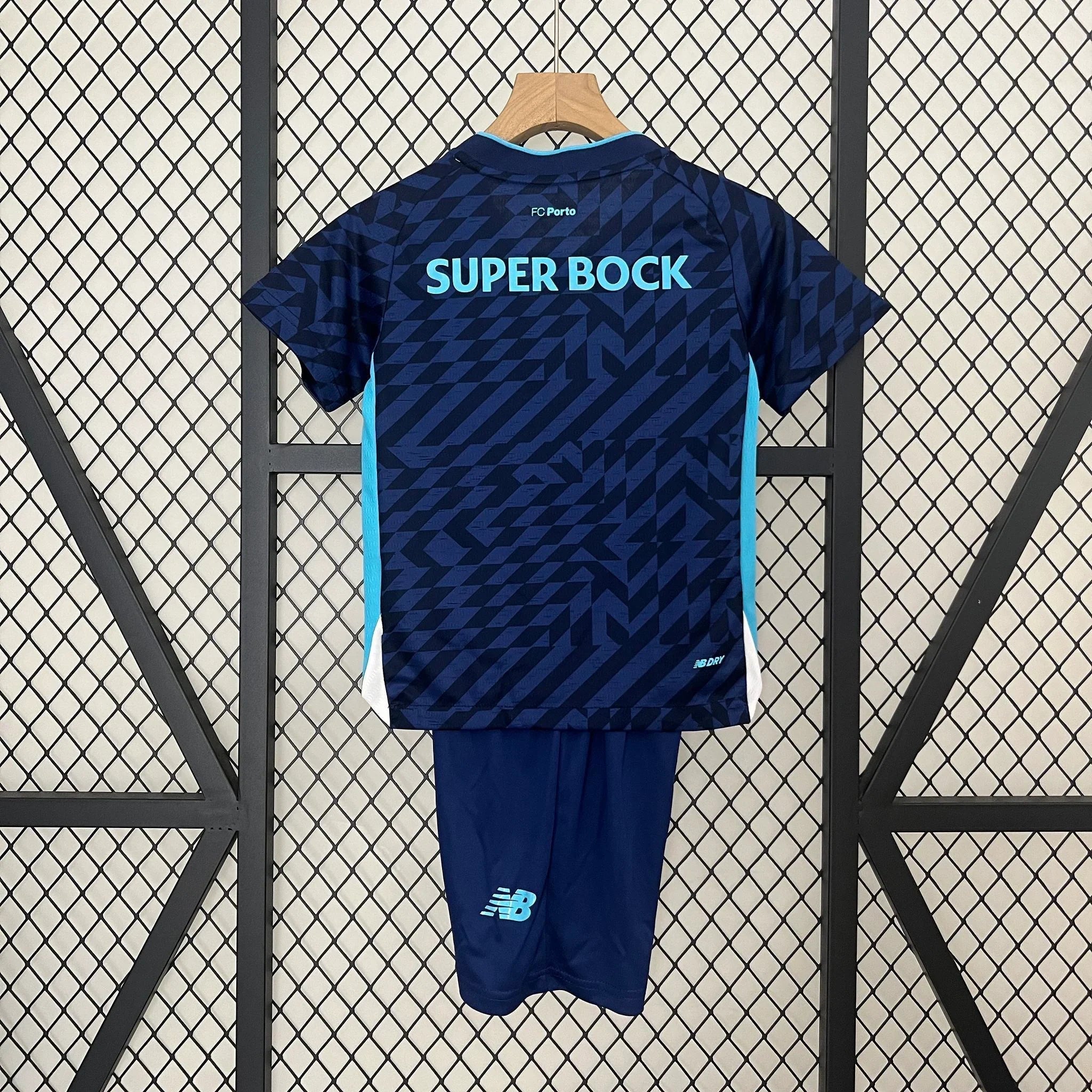 Jeune enfant portant le kit Porto 2024-25 de Le 12 -ème Maillot, maillot et short assortis, en tissu léger et coloré.