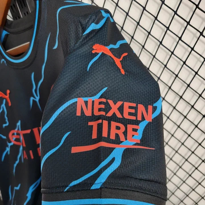 Maillot Manchester City saison 2023-2024 édition spéciale de la marque Le 12 -ème Maillot, vue de face avec logo et design officiel