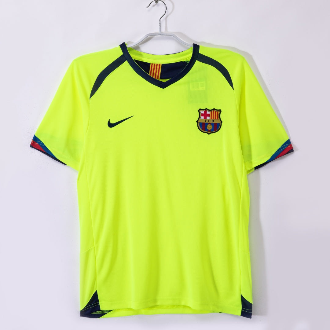 Maillot extérieur rétro du FC Barcelone 2005-2006, marque Le 12, avec logo et design classique visible sur le maillot.