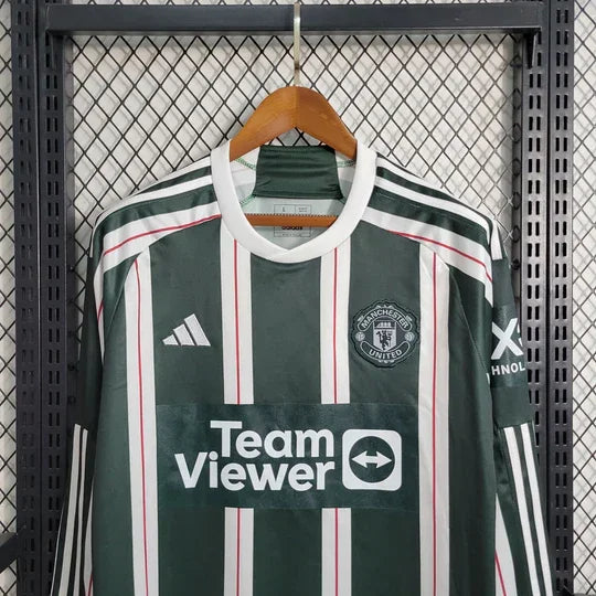 Maillot extérieur Manchester United 2023 2024 manches longues Le 12 -ème Maillot, bleu avec logo du club visible.