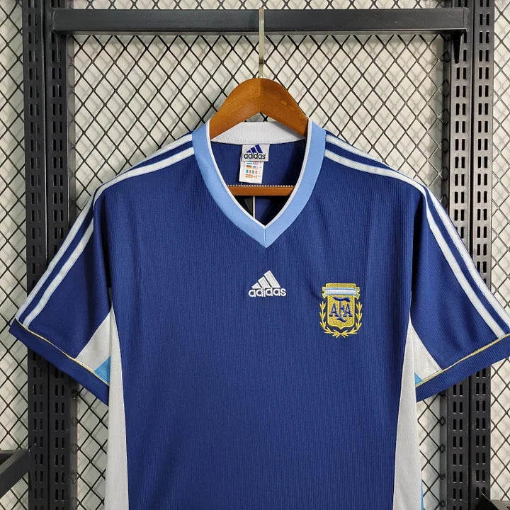 Maillot Argentine Retro 1998 Le 12-ème Maillot, maillot de football bleu avec détails argentés et logo de l'équipe.