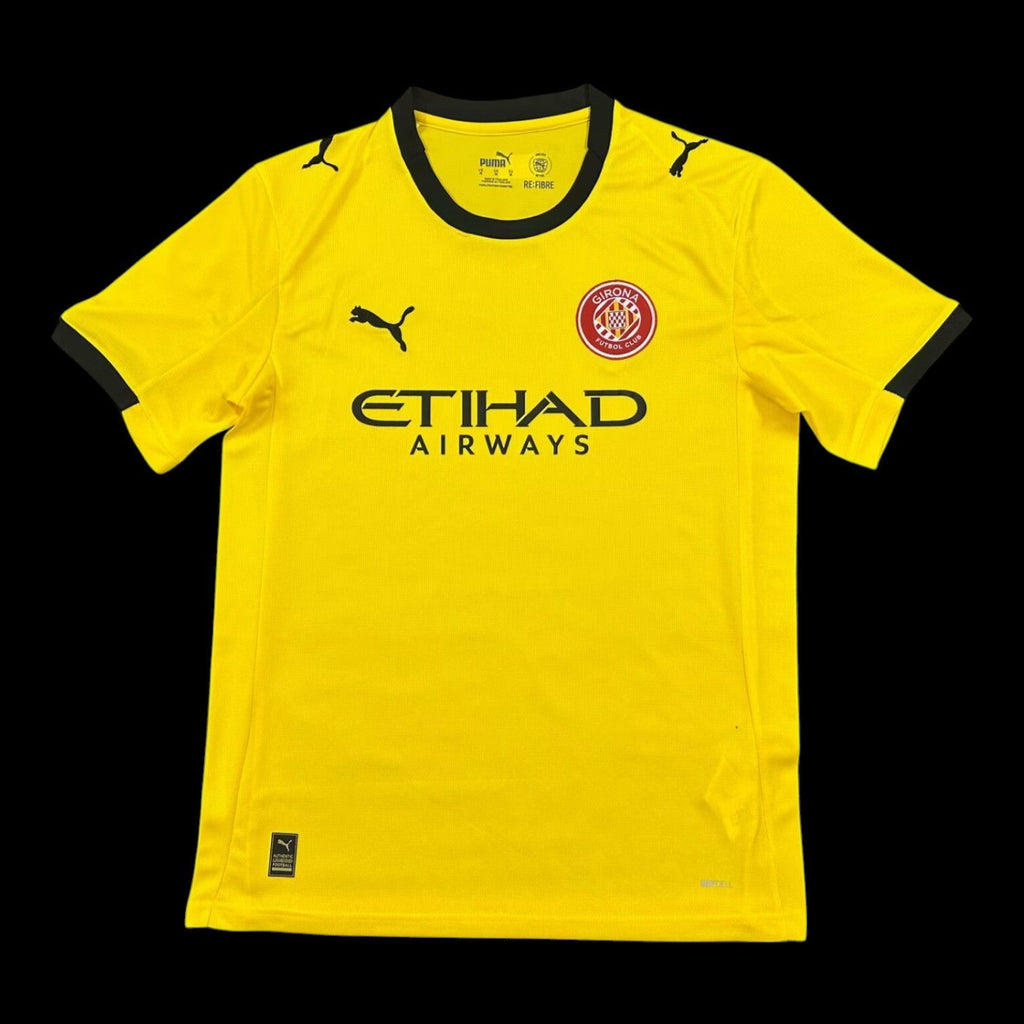 Maillot extérieur Girona 25/26 de la marque Le 12 -ème Maillot, en tissu bleu avec logo de l'équipe.