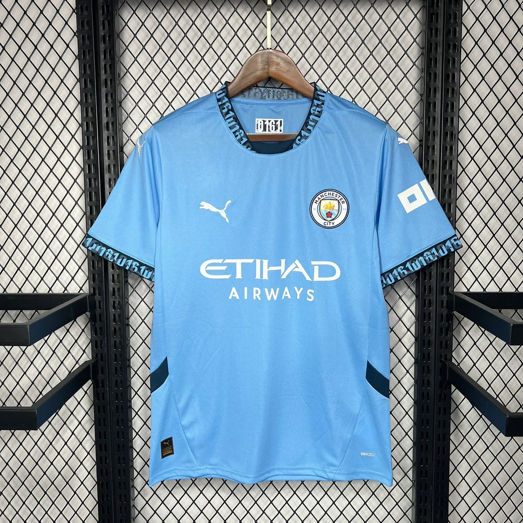Maillot domicile Manchester City 2024/25, marque Le 12 -ème Maillot, vue de face avec logo et détails du maillot bleu.