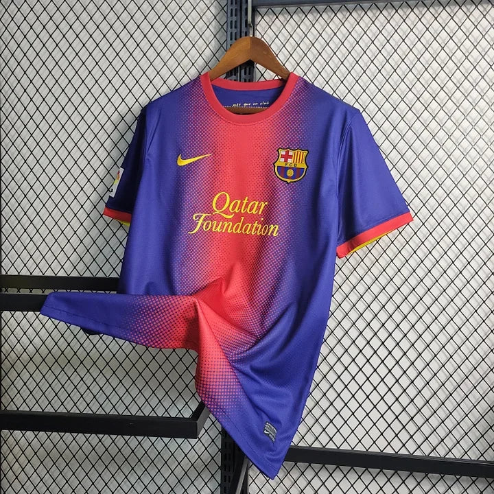 Maillot rétro FC Barcelone 2012/13 Le 12, maillot de football bleu avec le logo du club et les sponsors visibles.