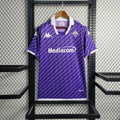 Maillot Fiorentina 2023-24 de Le 12 -ème Maillot, maillot de football violet avec logo et détails de l'équipe.