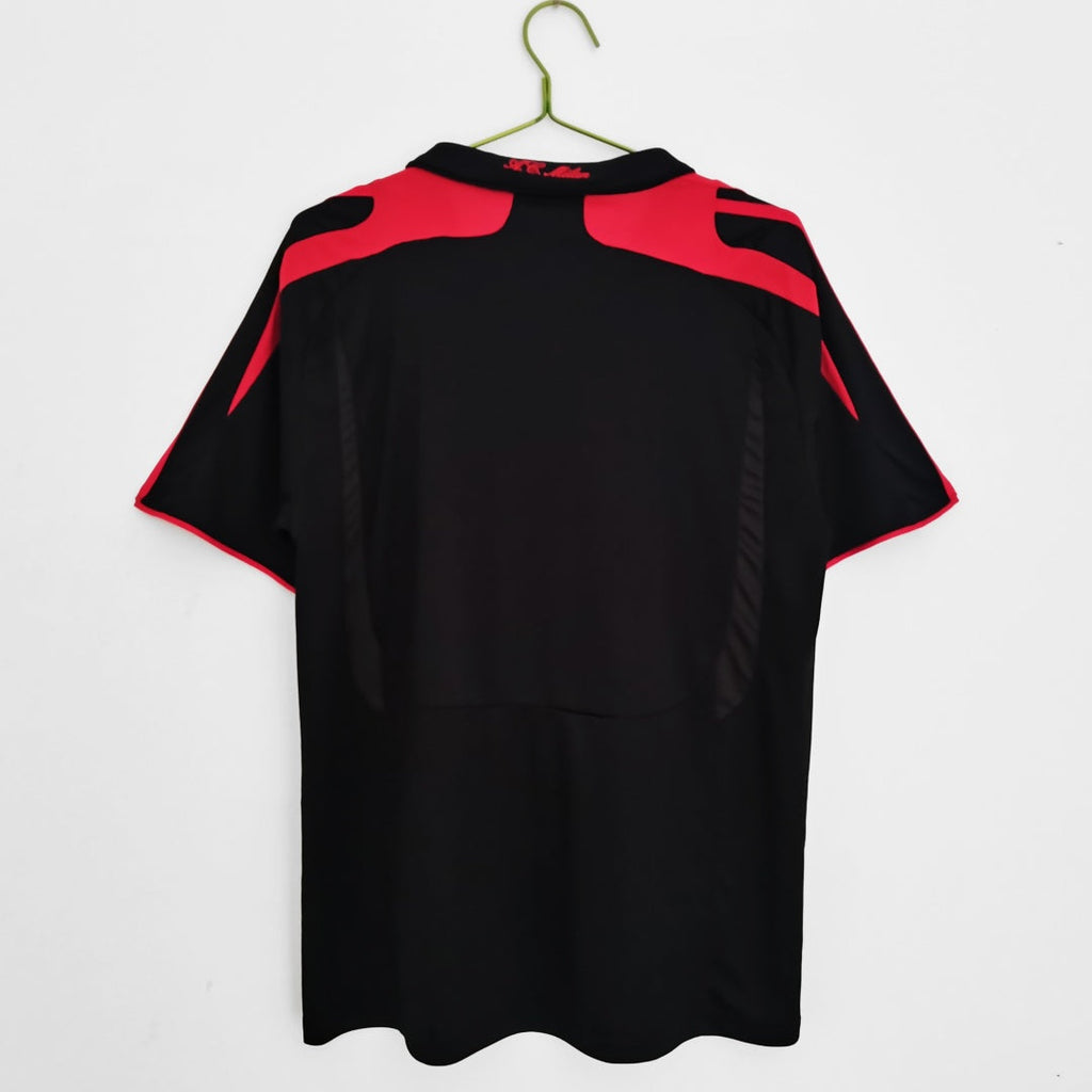Maillot rétro third de l'AC Milan 2007-2008, marque Le 12, avec logo et design vintage visible sur le maillot.