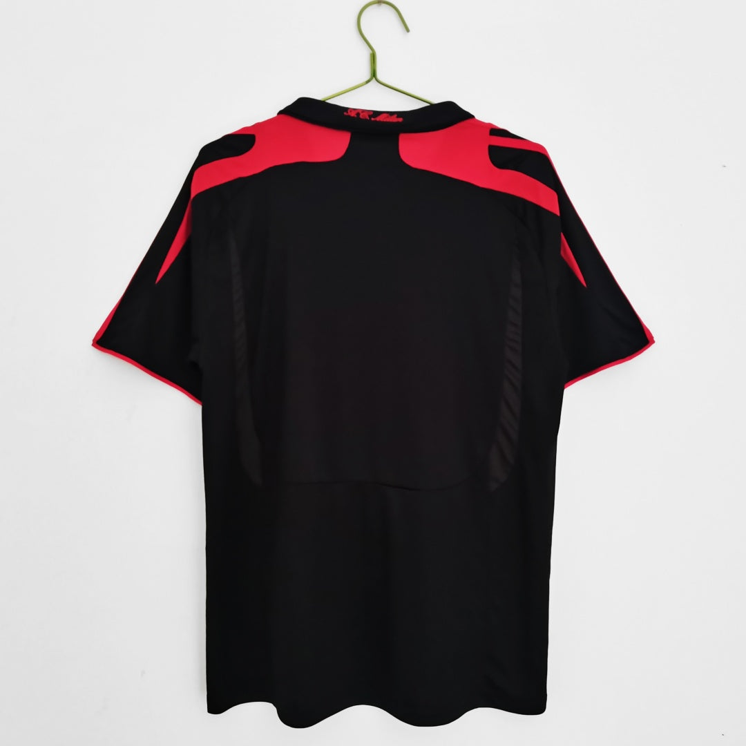 Maillot rétro third de l'AC Milan 2007-2008, marque Le 12, avec logo et design vintage visible sur le maillot.
