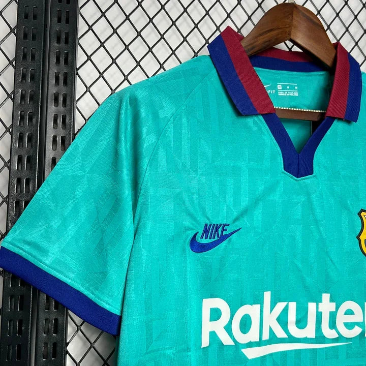 Maillot de football rétro FC Barcelone 2019-2020, manches bleues et écusson du club, porté par un mannequin.