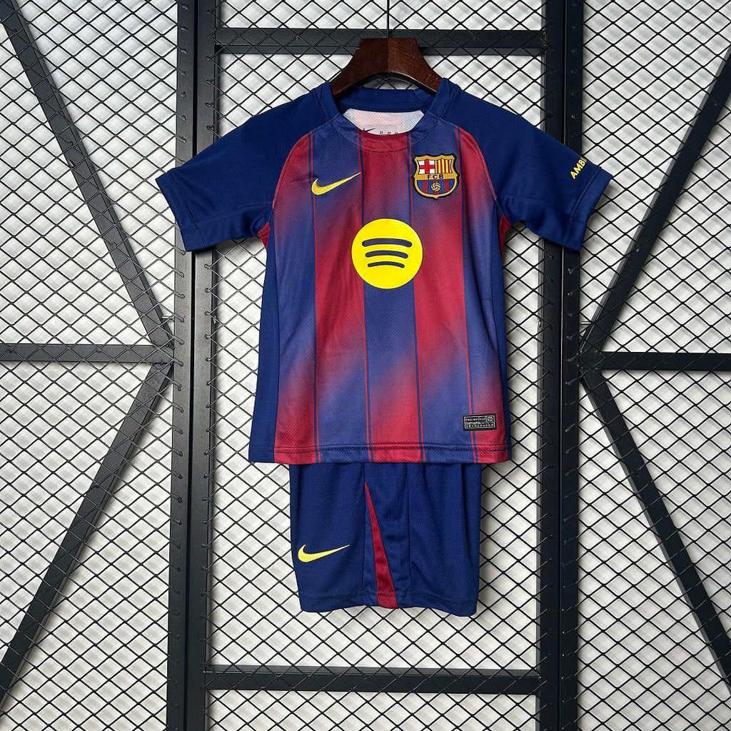 Enfant portant le kit FC Barcelone 2025-26, maillot et short de football de la marque Le 12, à l'entraînement.