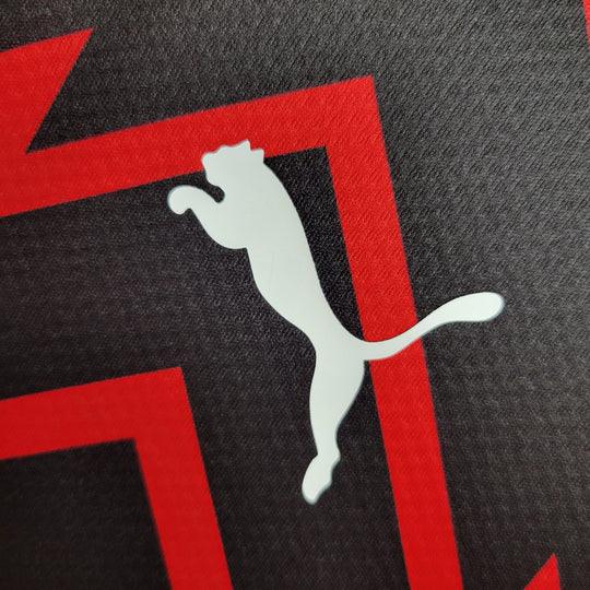 Maillot d'entraînement AC Milan 2023-2024 Le 12-ème Maillot, maillot de football rouge et noir avec logo du club visible.