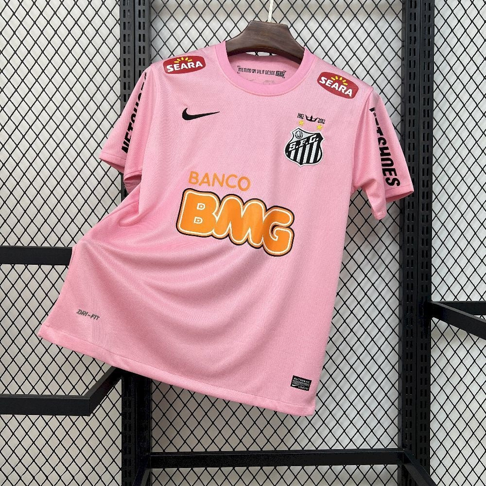 Maillot de football 11/12 Santos Retro rose par Le 12 -ème Maillot, vue de face avec logo et détails colorés.