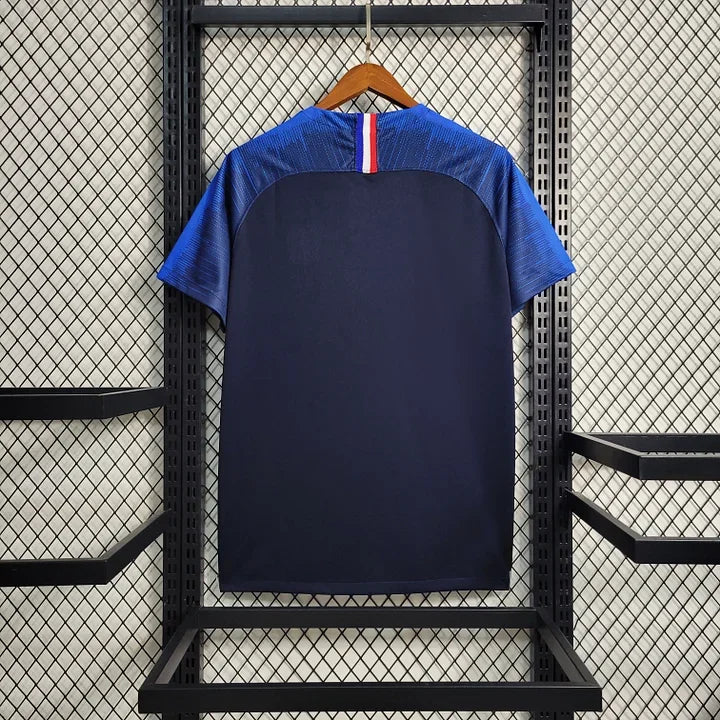 Maillot rétro de l'Équipe de France 2018, marque Le 12 -ème Maillot, vue avant avec logo et design bleu et blanc.