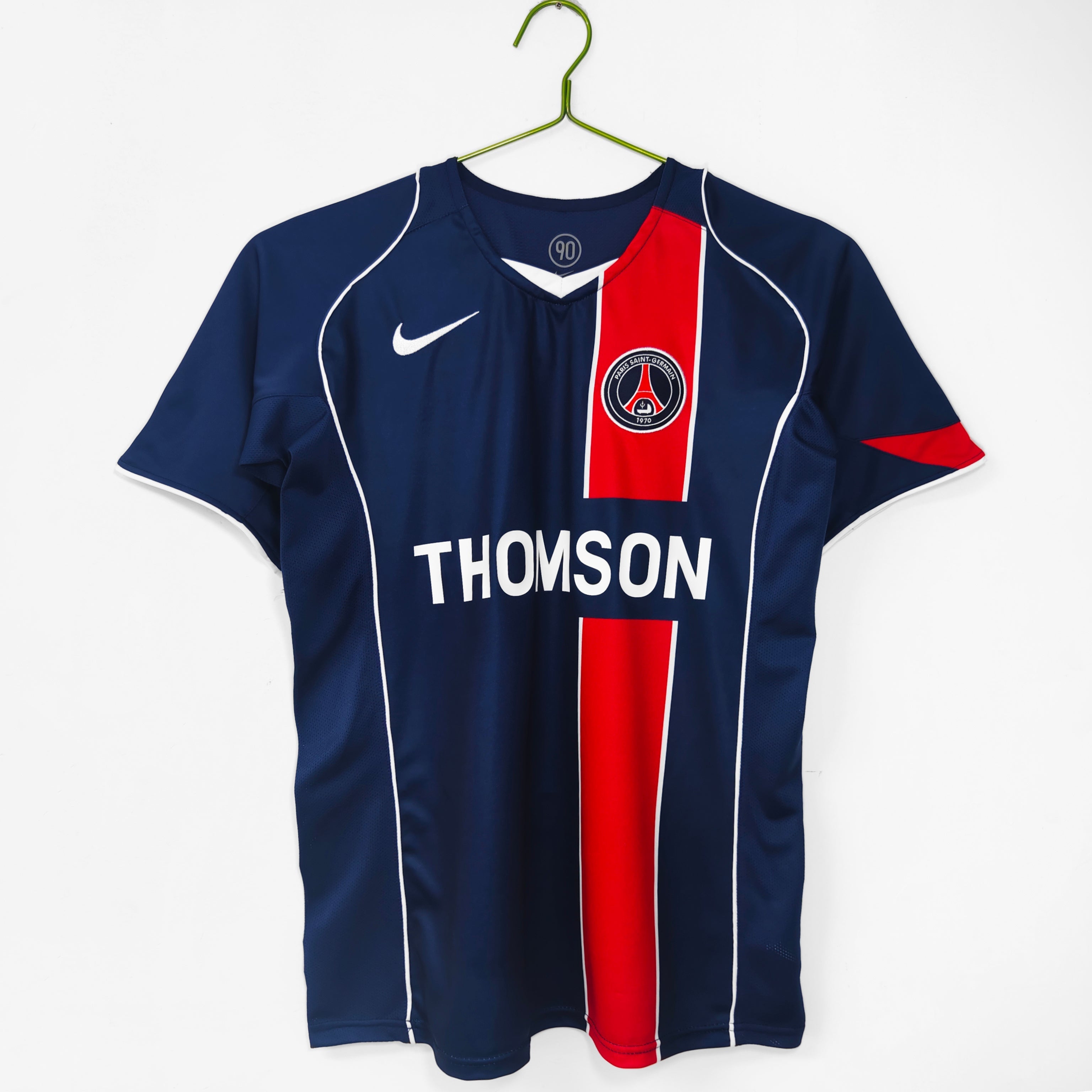 Maillot domicile rétro PSG 2004-2005 Le 12-ème Maillot, maillot de football rouge avec logo du Paris Saint-Germain visible.