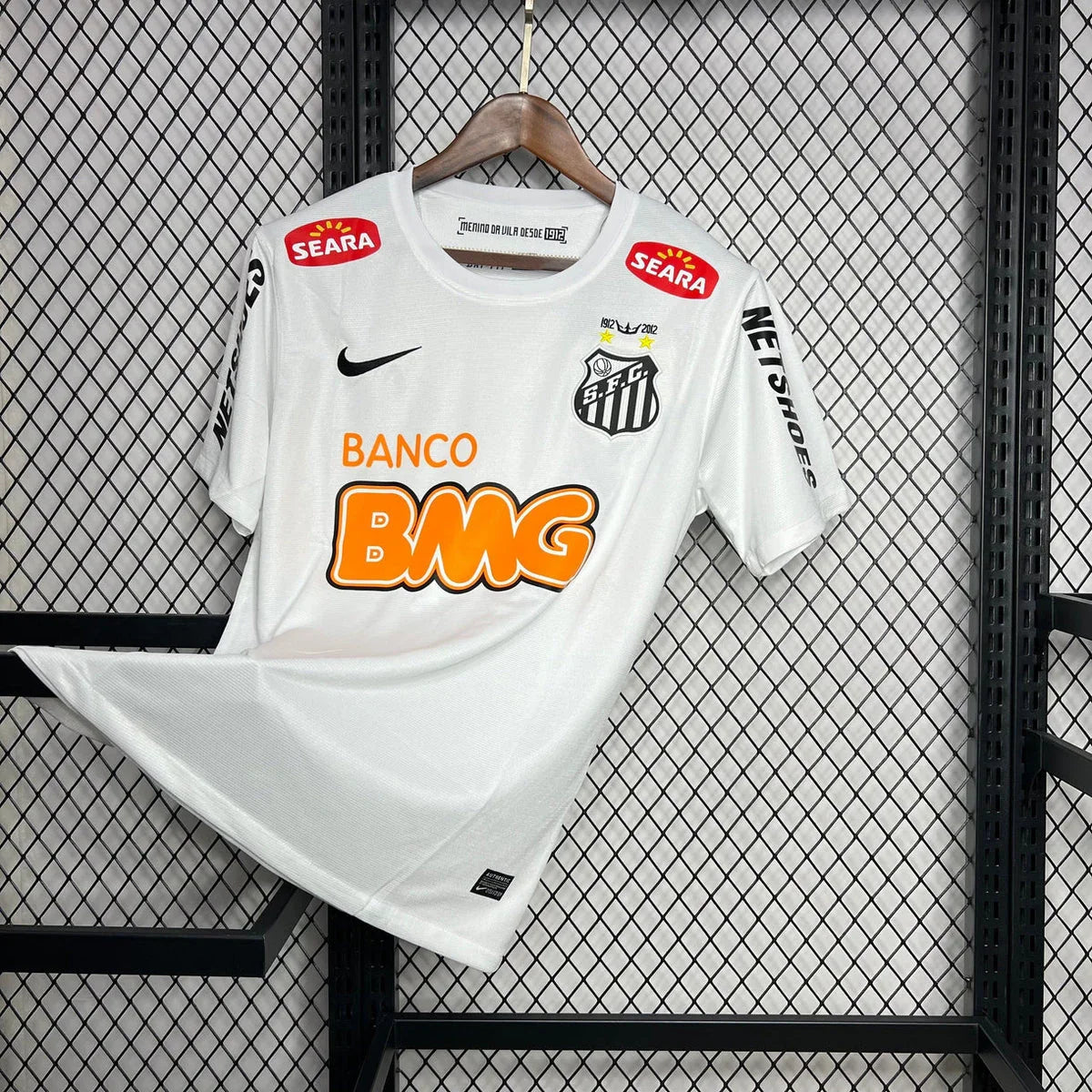 Maillot rétro Santos 2011-12 de la marque Le 12-ème, maillot de football orange avec logo et détails historiques.
