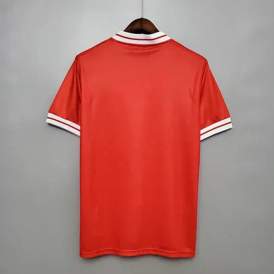 Maillot rétro Liverpool 1984, blanc avec logo et détails rouges, porté par un mannequin, version vintage du maillot de football Le 12-ème Maillot.