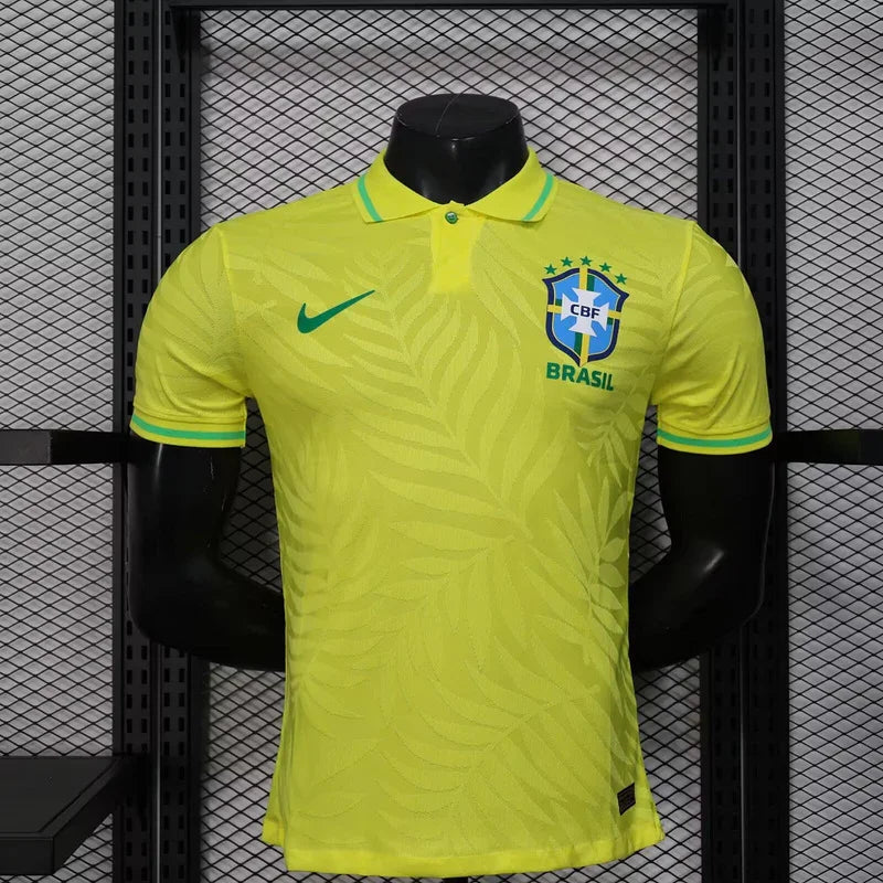 Maillot de football Brésil 2025-26, conçu par Le 12, affichant le logo de l'équipe nationale sur fond coloré.