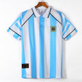 Maillot domicile rétro de l'Argentine 1996-1997, marque Le 12, avec logo et détails colorés sur fond bleu clair.