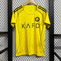 Maillot domicile de football Al-Nassr 25/26, marque Le 12, portant les couleurs officielles de l'équipe sur le terrain.