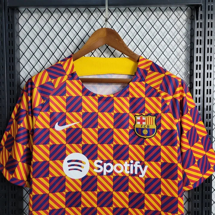 Maillot d'entraînement Barcelone FC 2023 2024 de Le 12, tissu léger, logo du club et motifs bleus et rouges visibles.