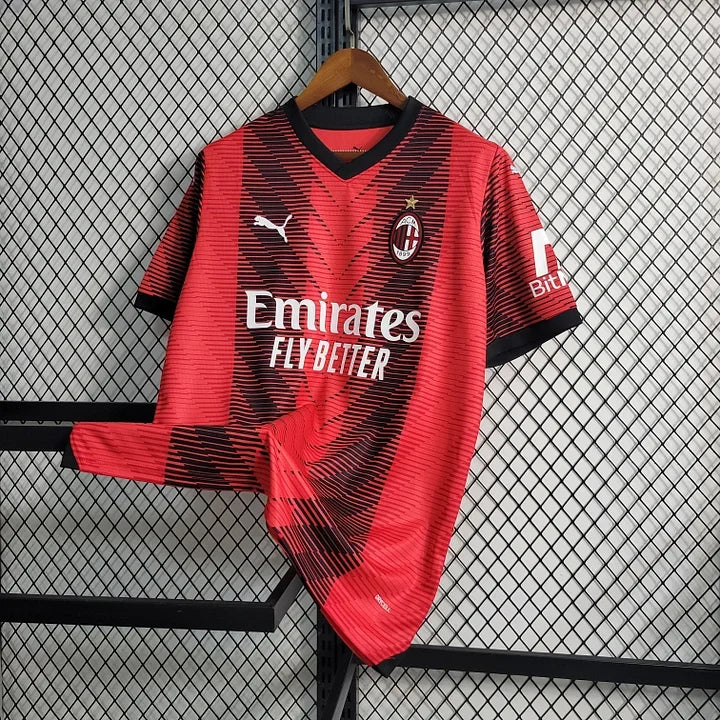 Maillot domicile de l'AC Milan 2023-2024, marque Le 12 -ème Maillot, porté par un supporter, en tissu rouge et noir avec logo.