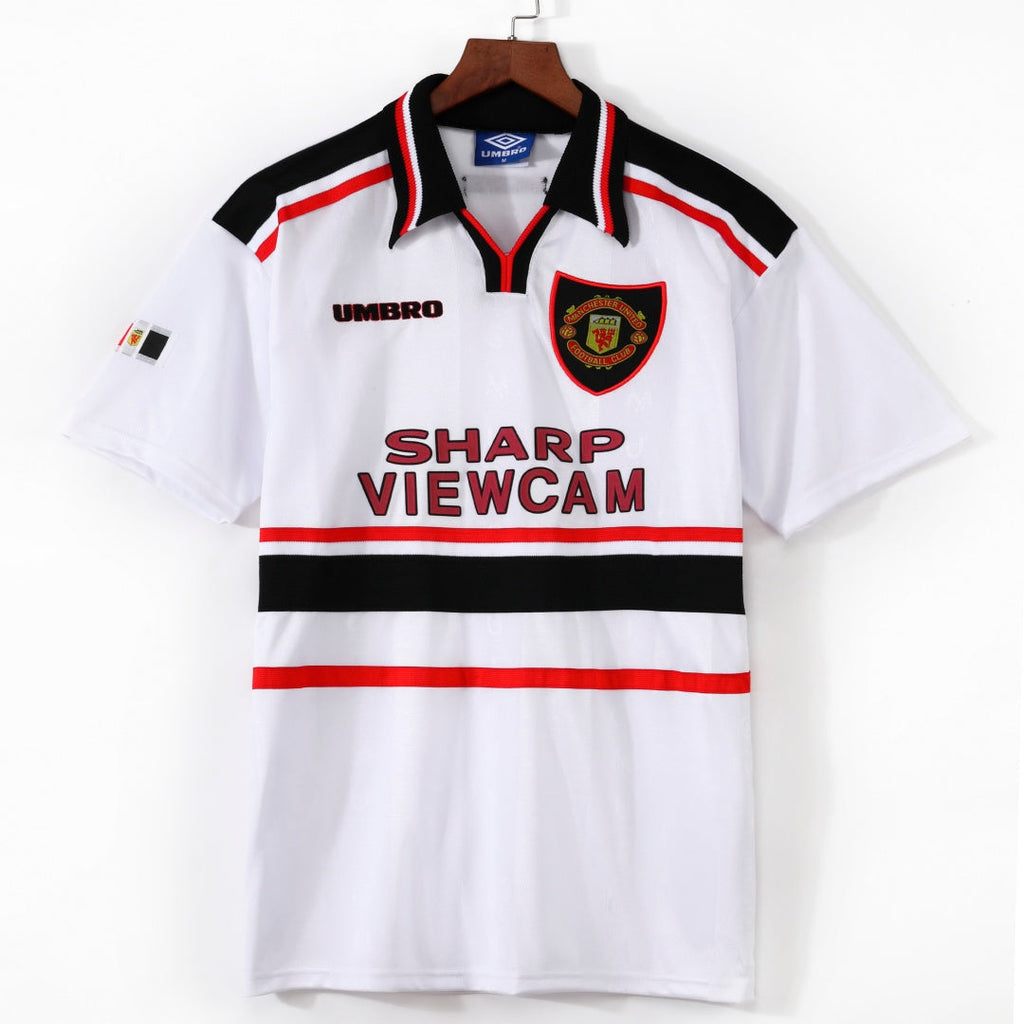 Maillot rétro extérieur Manchester United 1998-1999, marque Le 12-ème Maillot, en tissu rouge avec logo et détails blancs