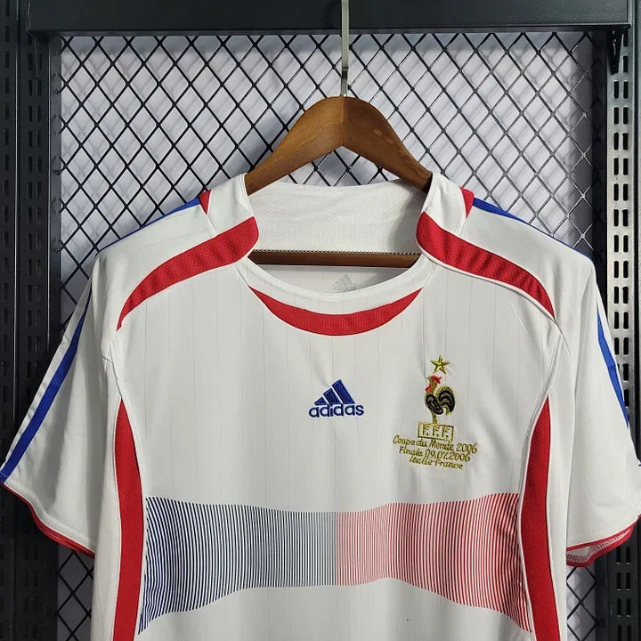 Maillot rétro de l'équipe de France 2006, modèle Le 12 -ème Maillot, vue de face avec logo et détails en bleu, blanc et rouge.