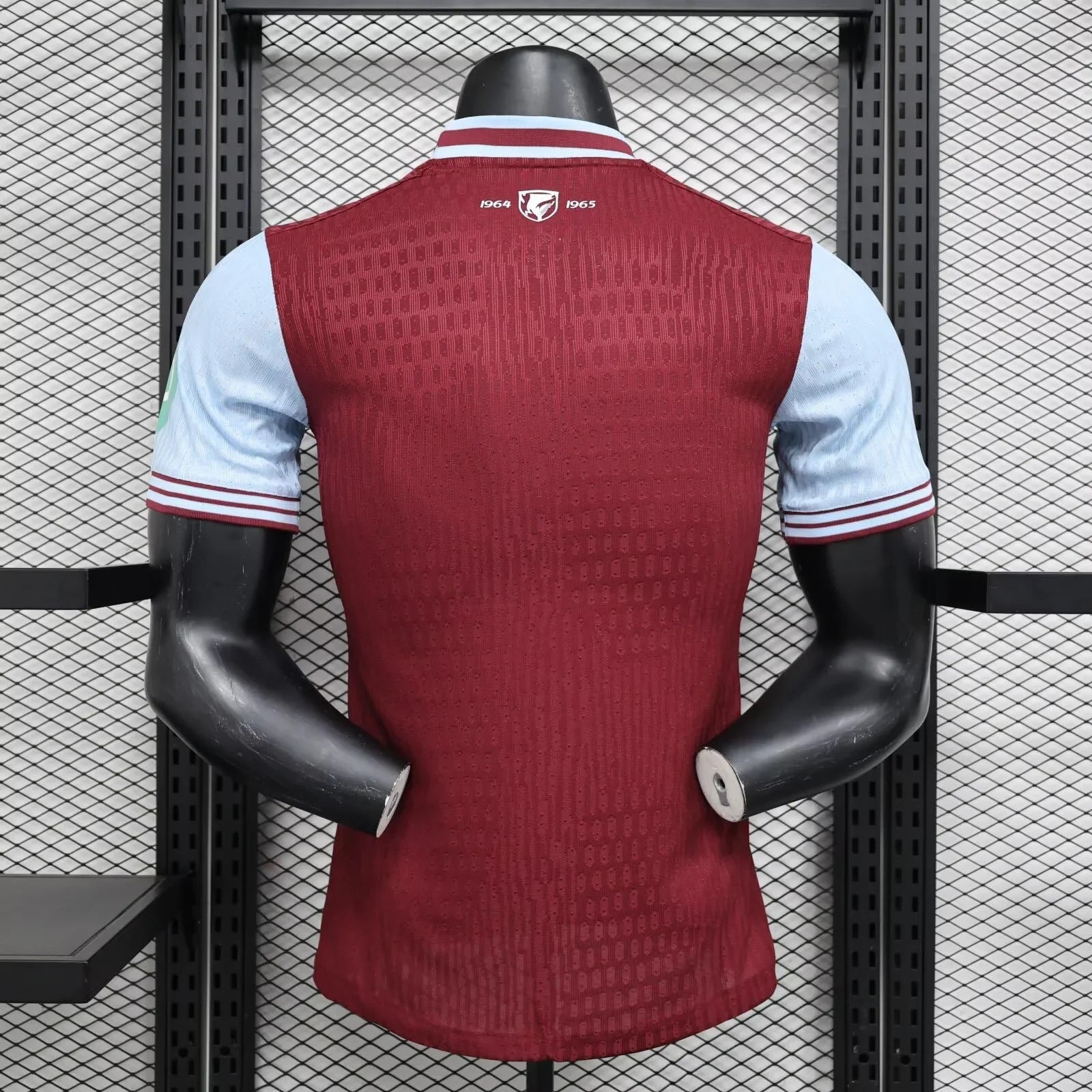 Maillot West Ham 2024-25, sportwear officiel de football, en tissu bleu avec logos et détails en blanc, porté par un mannequin.